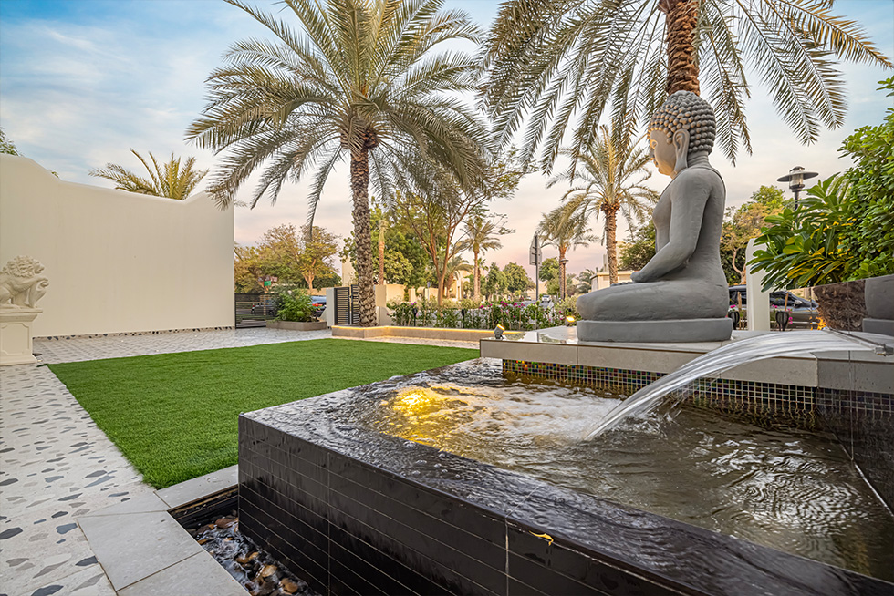 A group of people enjoying a lush outdoor landscape designed by Living Acre in Dubai.